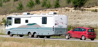 Motorhome towing small car behind it. 